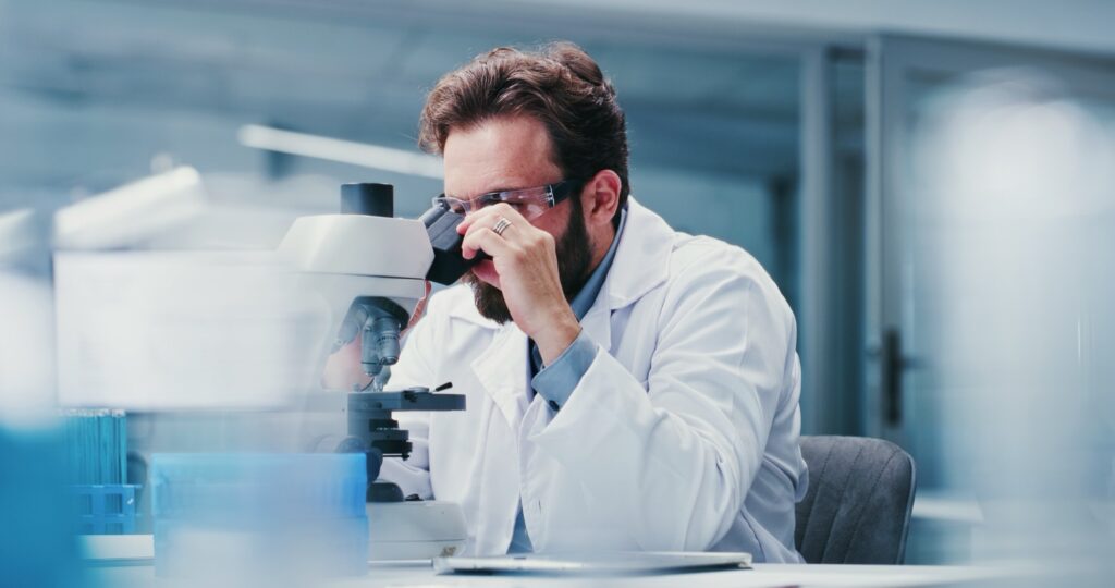 Człowiek, naukowiec lub mikroskop z okularami w laboratorium do badań medycznych, badań lub egzaminów. mężczyzna, biotechnologia lub eksperyment z testem do badań kryminalistycznych, próby klinicznej lub wyników