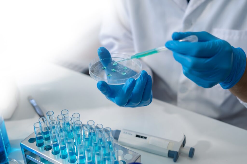 W laboratorium lekarz trzyma probówkę, która pobiera test z probówki do analizy, krwi, dna, probówki